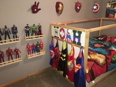 there are many toy action figures on the shelves in this room, including captain america and iron man