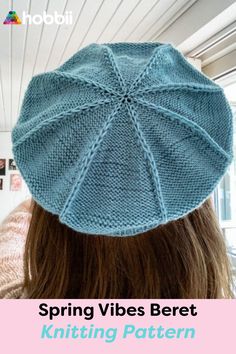 the back of a woman's head wearing a blue knitted hat