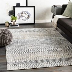 a living room area with a couch, coffee table and rugs on the floor