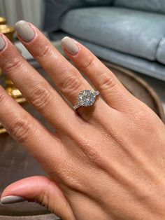 a woman's hand with a diamond ring on her finger and the other hand