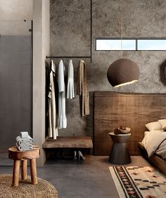 a bedroom with concrete walls and wooden furniture