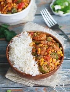 a wooden bowl filled with rice and vegetables next to a plate of food on top of a table