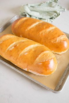 two loaves of bread sitting on top of a pan