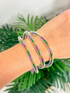 This set of 3 jelly bangle bracelets is perfect for accessorizing any Mardi Gras outfit. Durable and stylish, the bracelets feature a glossy, eye-catching finish that will stand out in any crowd. Plastic Bangle Jewelry For Party, Trendy Plastic Bangle Jewelry, Trendy Plastic Bangle Bracelets, Party Stackable Beaded Bangle Bracelets, Stackable Beaded Bangle Bracelets For Party, Stackable Beaded Bracelets For Party, Colorful Plastic Beads Jewelry For Party, Plastic Beaded Jewelry For Party, Colorful Beads Plastic Party Jewelry