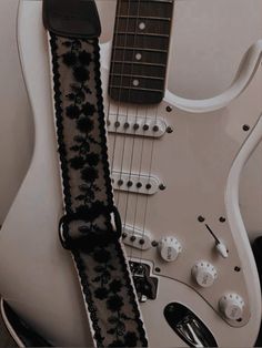 a white guitar with black lace on it