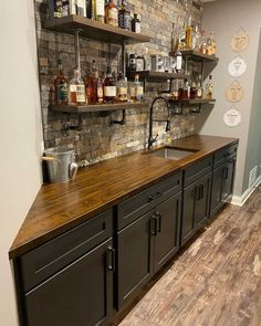 a bar with lots of liquor bottles on the wall and shelves above it that are made out of wood