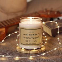 a cup of coffee and my favorite book candle sits on a table next to a guitar