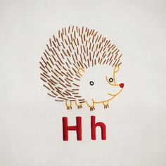 an embroidered hedgehog with the letter h on it's back and red letters underneath