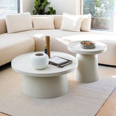 a living room filled with white furniture and a large window overlooking the cityscape