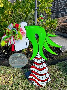 a green and white christmas decoration sitting in the grass