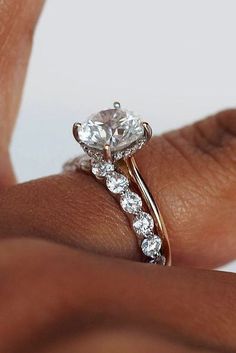 a close up of a person's hand holding a diamond ring