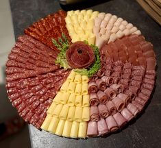 an assortment of meats and cheeses arranged on a platter