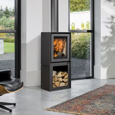 a living room with a chair and fire place inside of it, next to a large window