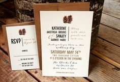 wedding stationery with pine cones on the front and back, sitting on a wooden table