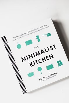 the minimalist kitchen cookbook sits open on a white countertop next to a knife and fork