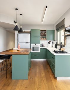 a kitchen with wooden floors and green cabinets