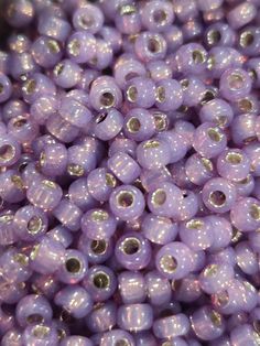 purple beads are stacked on top of each other in this close up photo, with the beading visible