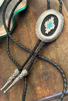 This awesome bolo tie has a southwestern design and real turquoise stone inlay.  The cord is genuine leather.   Measurements/Sizing   Total length of leather is approx. 40 inches 1 1/4'' x 2 1/4'' in pendant Western Style Concho Jewelry As Gift, Southwestern Concho Bolo Tie As Gift, Western Style Hand Tooled Bolo Ties As Gift, Western Style Concho Jewelry For Gift, Western Style Concho Bolo Tie For Gift, Hand Tooled Western Bolo Ties As Gift, Southwestern Bolo Ties With Concho For Ranch, Southwestern Style Jewelry As A Gift, Southwestern Style Jewelry As A Gift With Adjustable Length