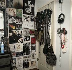 a room with many posters and headphones hanging on the wall next to a door