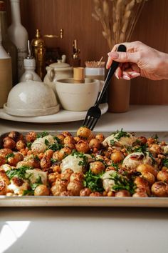 a person is cutting up some food on a pan