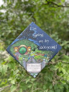 a graduation cap hanging from a tree with writing on it