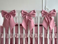 pink crib bedding with large bows on the top and bottom rail for baby's crib