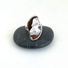 This is an unusual mother of pearl stone ring. The vintage sterling silver ring has a unique nacre stone. It has striking markings set in an unusual shaped crown. The ring has tested positive for sterling silver and is marked 925 inside the band. The womens or mens ring is a UK size O and US size 7 1/2. The crown is approx 1 1/8 inches (3cm) at its longest. The ring is in great vintage condition but has been left as found. It can be cleaned if requested. See ReTain ReUse for other gift ideas, be Oval Mother Of Pearl Ring Gift, Oval Mother Of Pearl Ring For Gift, Oval Mother Of Pearl Ring With Polished Finish, Oval Mother Of Pearl Ring Perfect For Gift, Silver Mother Of Pearl Anniversary Ring, Unique Polished Pearl Ring Gift, Unique Polished Pearl Ring As Gift, Unique Polished Pearl Ring For Gift, Sterling Silver White Inlay Ring