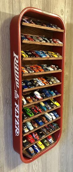 a red toy car storage rack on a wooden wall