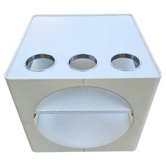 a white box with three bowls on the front and two holes in the back that are open