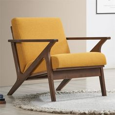 a yellow chair sitting on top of a rug in front of a white wall and floor