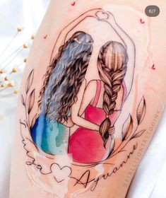 two girls hugging each other with watercolor tattoos on their thighs and arms, behind them is a heart