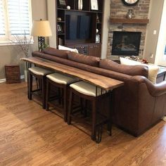 a living room filled with furniture and a flat screen tv mounted on a wall next to a fire place