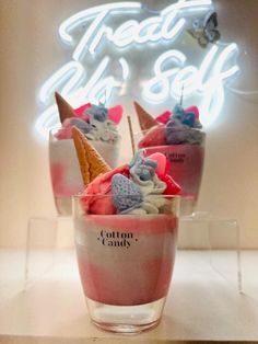 three ice cream sundaes in front of a neon sign