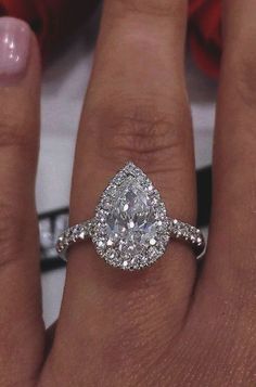 a woman's hand with a diamond ring on top of her finger and an engagement band