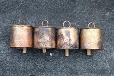 four old rusty metal pots sitting on top of each other