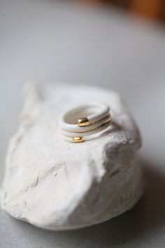 three gold rings sitting on top of a white piece of rock next to each other