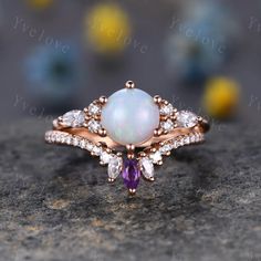 an opal and diamond ring on top of a rock