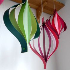 three colorful paper ornaments hanging from a ceiling