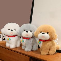 three stuffed dogs sitting on top of a wooden table next to a mirror and clock