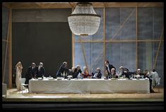 a group of people sitting at a table in front of a chandelier