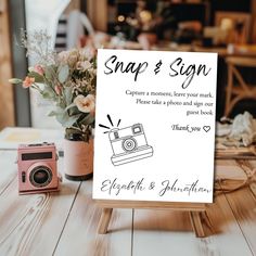 a sign that says snap & son on it next to a camera and flower arrangement