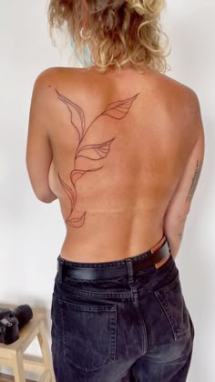 the back of a woman's body with tattoos on it