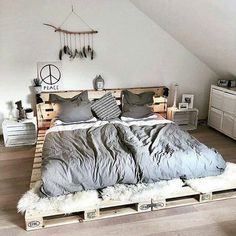 a bed made out of pallets in a room with white walls and wooden floors