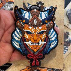 a person holding up a colorful cat shaped sticker in their left hand and another image of an animal on the right