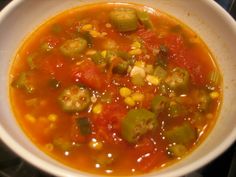 a white bowl filled with vegetable soup on top of a stove