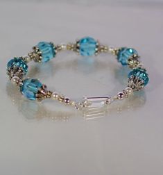 This beautiful bracelet is made with gorgeous 10mm Light Turquoise Swarovski crystal rounds, 4mm white Swarovski pearls, silver bead caps, silver beads, and has a silver foldover clasp.  Bracelet can be made to fit any wrist size.  Several clasp styles available - shown with the silver fold over, I can also make it adjustable (with a spring ring or lobster clasp and extension), a toggle clasp, magnetic, or a hook and eye. Just contact me with your order regarding the clasp style you prefer.** Co Elegant Turquoise Birthstone Bracelets, Elegant Turquoise Crystal Bracelet With Spacer Beads, Elegant Nickel Free Turquoise Beaded Bracelets, Elegant Nickel-free Turquoise Beaded Bracelets, Elegant Turquoise Crystal Bracelet With Faceted Beads, Adjustable Turquoise Crystal Bracelets, Handmade Blue Crystal Wedding Bracelet, Adjustable Blue Crystal Bracelet For Anniversary, Nickel Free Round Beads Bracelet For Wedding