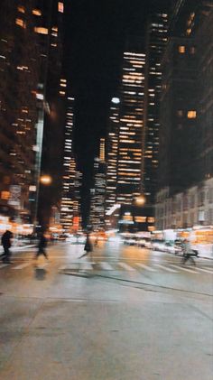 people crossing the street at night in a big city