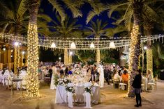 a wedding reception under palm trees at night