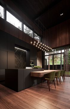 a dining room with wooden flooring and lights hanging from the ceiling, along with green chairs