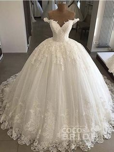 a white wedding dress on display in front of a mirror